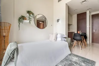 a white bedroom with a bed and a mirror at GuestReady - 1BR l Stylish City Escape in Dubai