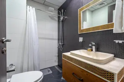 a bathroom with a sink and a toilet and a mirror at GuestReady - Studio | Stunning Burj Khalifa View in Dubai