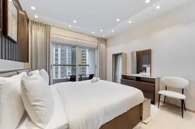 a bedroom with a large white bed and a desk at Bright 1BR Apartment in Elite Residence Marina in Dubai