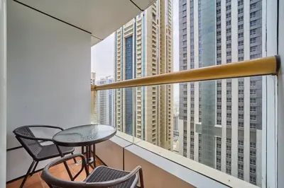 a balcony with a table and chairs and a view of skyscrapers at Bright 1BR Apartment in Elite Residence Marina in Dubai