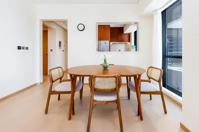 a dining room with a wooden table and chairs at Urban 1BR Retreat RP Heights Near Dubai Mall in Dubai