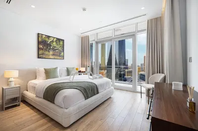 a white bedroom with a large bed and a desk at Burj Daman By Luxe Living - Future Museum & Emirates Towers Views in Dubai