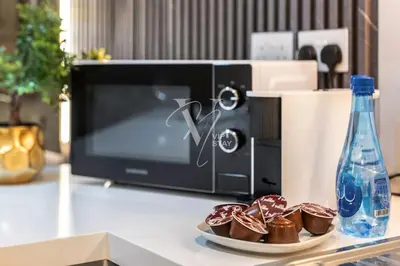 a microwave with a plate of chocolate muffins on a counter at La Vie Majestic 2BDR with Private Beach Access in Dubai