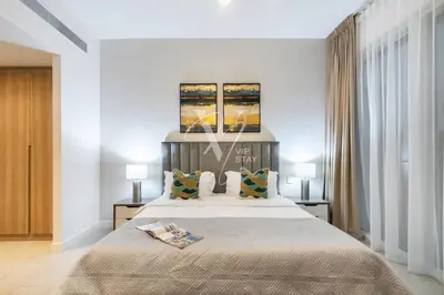 a bedroom with a large bed with two lamps at La Vie Majestic 2BDR with Private Beach Access in Dubai