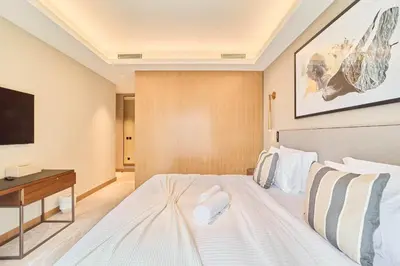 a bedroom with a white bed and a desk at Premium 2BR Address Opera Downtown Dubai in Dubai