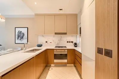 a kitchen with wooden cabinets and a sink at Premium 2BR Address Opera Downtown Dubai in Dubai
