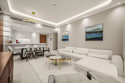 a living room with white furniture and a kitchen at Brand New Luxury 2BHK Apartment in Jadeel 2 MJL in Dubai
