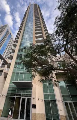 a woman walking in front of a tall building at Luxury 1BR Apartment at Burj Views Tower C - Downtown in Dubai