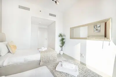 a white bedroom with a bed and a mirror at Luxurious 2 bedroom with Burj Khalifa views, connected to Dubai Mall in Dubai