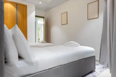 a white bedroom with two beds with white pillows at Morden 2BR With Full sea view -High floor in Dubai
