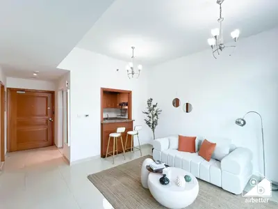 a living room with a white couch and a table at 1BR City Escape at Marina Residence Pool & Gym in Dubai