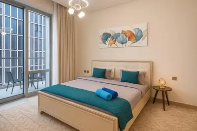 a bedroom with a bed with a blue pillow on it at Vida Dubai Mall - Luxury 1BR with Direct access to Dubai Mall in Dubai