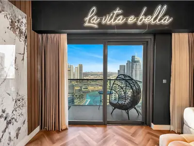 a living room with a view of a city at Fountain view Golden Era Cinema-Inspired 4BR APT in Dubai
