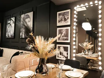 a dining room with a table with a vase with flowers at Fountain view Golden Era Cinema-Inspired 4BR APT in Dubai
