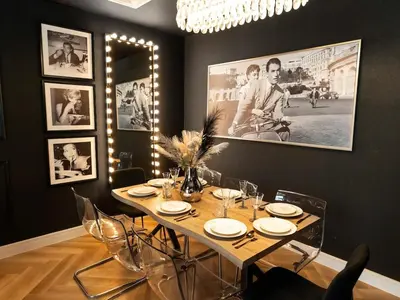 a dining room with a table with chairs and pictures on the wall at Fountain view Golden Era Cinema-Inspired 4BR APT in Dubai