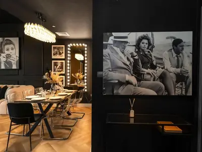 a dining room with tables and chairs and a large picture on the wall at Fountain view Golden Era Cinema-Inspired 4BR APT in Dubai
