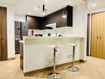 a kitchen with a counter with two stools in it at Skyline 19 1 Residences in Dubai