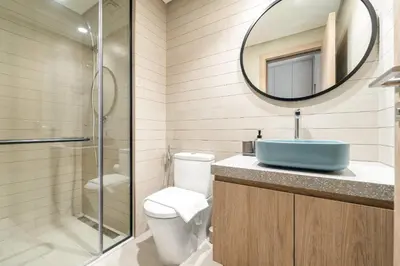 a bathroom with a sink and a toilet and a mirror at VayK - Bright Studio Overlooking The Canal in Business Bay in Dubai