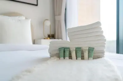 a stack of white towels on a bed at Relaxing Studio with Balcony & Pool in Haven Tower in Dubai