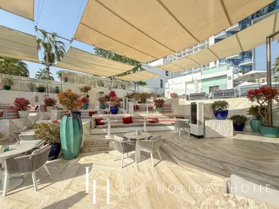 an outdoor patio with tables and chairs and plants at LUX The Five Palm Jumeirah Suite in Dubai