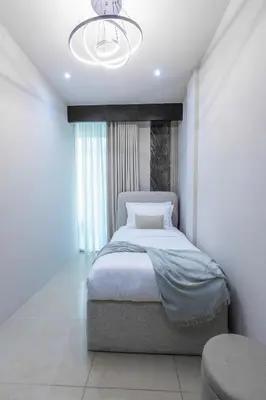 a bedroom with a bed and a chandelier at Stylish 2BR Oasis in Business Bay with Pool & Gym in Dubai