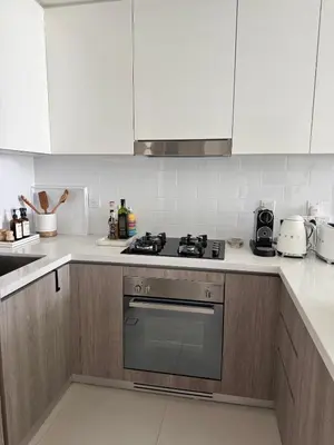 a kitchen with white cabinets and a stove top oven at Luxury 1Bed at LIV Marina Stunning Marina Views in Dubai