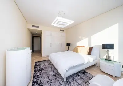 a white bedroom with a bed and a tv at JBR High Floor 2BR Stunning Ain Dubai View in Dubai
