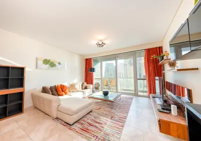 a living room with a couch and a tv at JBR High Floor 2BR Stunning Ain Dubai View in Dubai