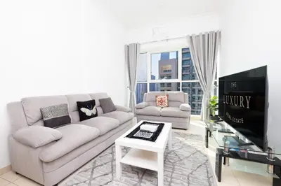 a living room with a couch and a tv at Modern 1BR -Canal Views & Burj Views -Business Bay in Dubai