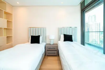 two beds in a room with a window at 2BR With Rooftop Pool Offering Burj Khalifa Views in Dubai