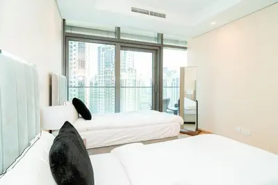 a bedroom with two beds and a large window at 2BR With Rooftop Pool Offering Burj Khalifa Views in Dubai