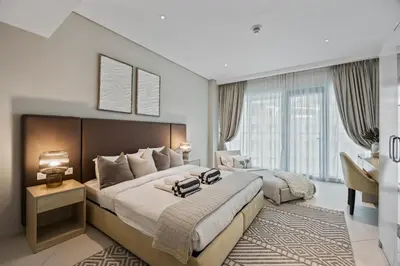 a hotel room with a large bed and a desk at Palm Jumeirah Sea-View Stay - Infinity Pool - Beach - Gym - Padel in Dubai