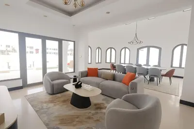 a living room with a couch and chairs and a table at BLVD Beach House in Dubai