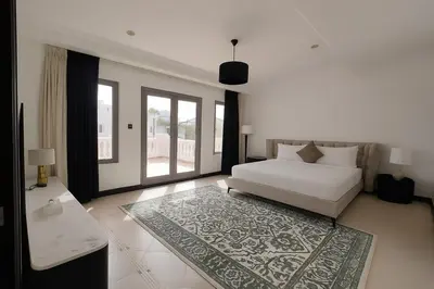 a bedroom with a white bed and a rug at BLVD Beach House in Dubai