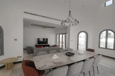 a white living room with a table and chairs at BLVD Beach House in Dubai