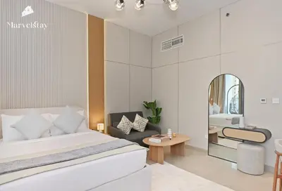 a bedroom with a bed and a chair and a mirror at MarvelStay - Beach 5 mins - Fits 3 - Pool-Gym-Sauna - Marina in Dubai