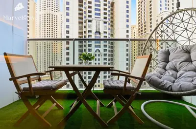 two chairs and a table on a balcony at MarvelStay - Beach 5 mins - Fits 3 - Pool-Gym-Sauna - Marina in Dubai