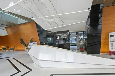 a lobby with a white counter in a building at MarvelStay - Beach 5 mins - Fits 3 - Pool-Gym-Sauna - Marina in Dubai