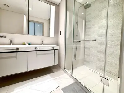 a bathroom with a glass shower and a sink at Direct Beach Access 2BHK in Dubai