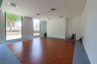 an empty room with a wooden floor and two windows at Exclusive 2BR in Rahaal 2, Madinat Jumeirah Living in Dubai
