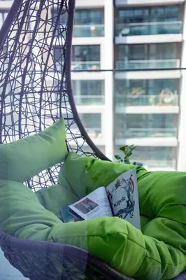 a hammock chair with a book and a book at Frank Porter - Grove by Eman in Dubai