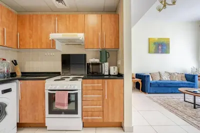 a kitchen with a stove top oven next to a living room at Two Bedroom with Full marina view in Dubai