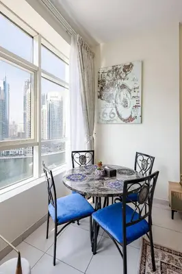 a dining room with a table and chairs and a window at Two Bedroom with Full marina view in Dubai