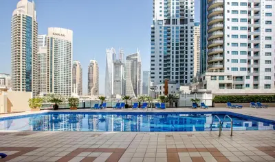 a large swimming pool in a city with tall buildings at Two Bedroom with Full marina view in Dubai