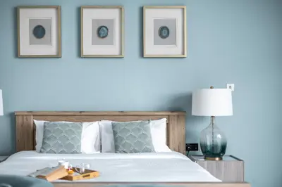 a bedroom with a bed with three pictures on the wall at Beachfront Boho Bliss Direct Beach Access in Dubai