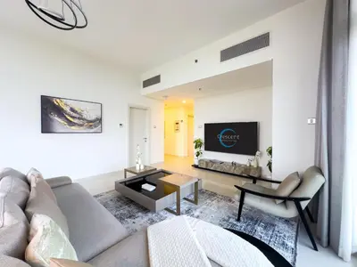 a living room with a couch and a tv at Greenery Haven 2 Bed plus Study in Damac Hills in Dubai
