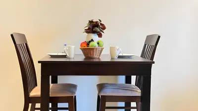 a table with a bowl of fruit on it with two chairs at Elite Studio with Burj Khalifa & Pool View in Dubai