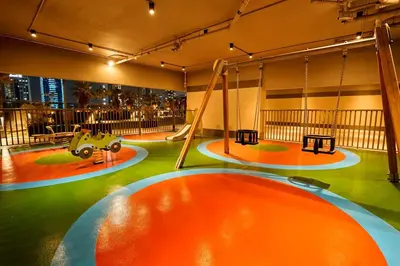 a play area with swings and a playground at Elite Studio with Burj Khalifa & Pool View in Dubai
