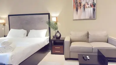a hotel room with two beds and a couch at Elite Studio with Burj Khalifa & Pool View in Dubai
