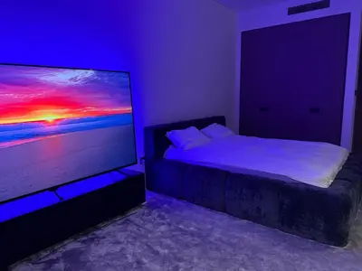 a bedroom with a bed and a flat screen tv at Stylish Studio with Burj Khalifa Views in Dubai